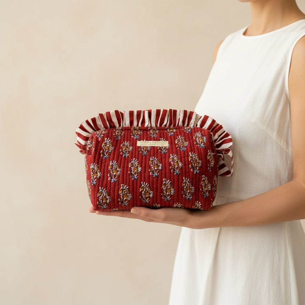  Femme tenant une trousse de toilette brodée bordeaux à franges, fabrication artisanale, collection Chacha d'Amour